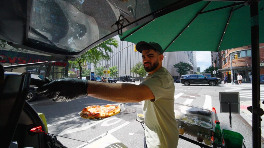 A 38-year-old man runs a mobile pizza shop in New York City using a smart car.